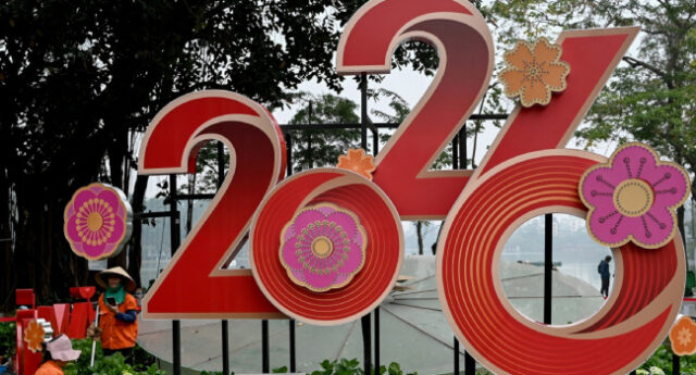 Workers-tend-to-flowers-next-to-a-2026-New-Year-banner-in-Hanoi-on-December-31-2025.-Photo-by-Nha